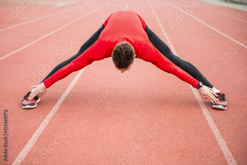 Doing some stretching before a run. Young athlete getting ready for a run.