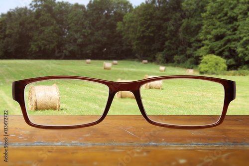 Brille auf dem Tisch mit landwirtschaftlichem Hintergrund photo