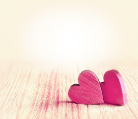 Two red hearts on wooden background