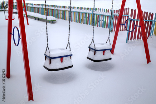 Children's playground covered with snow in winter photo