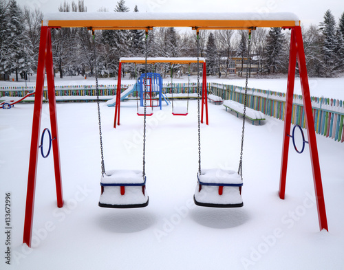 Children's playground covered with snow in winter photo