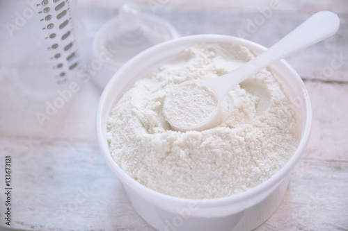 Some milk powder served with a scoop while preparing a baby bottle. Empty copy space for editor's text.