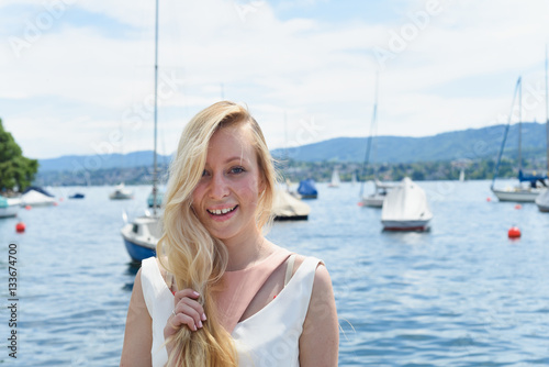 Happy young woman in dress on the lake in Zurich, Switzerland