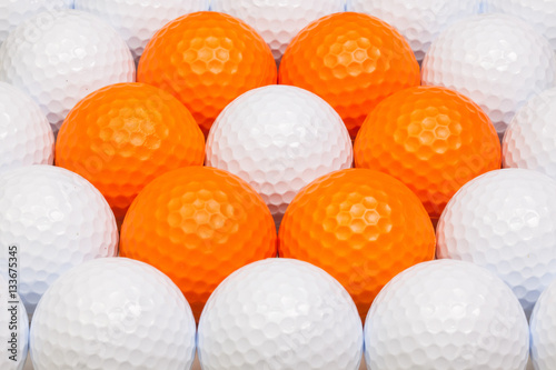 White and orange golf balls in the box