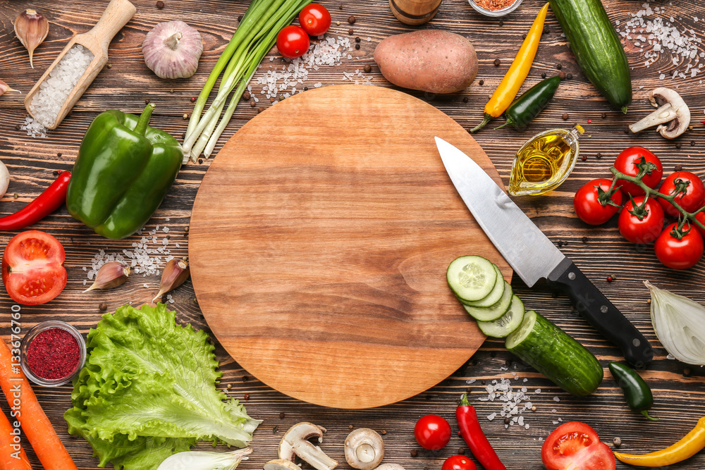 Cutting board and vegetables on wooden background - obrazy, fototapety, plakaty 