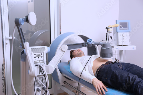 Inductive shortwave diathermy for young man in modern clinic photo