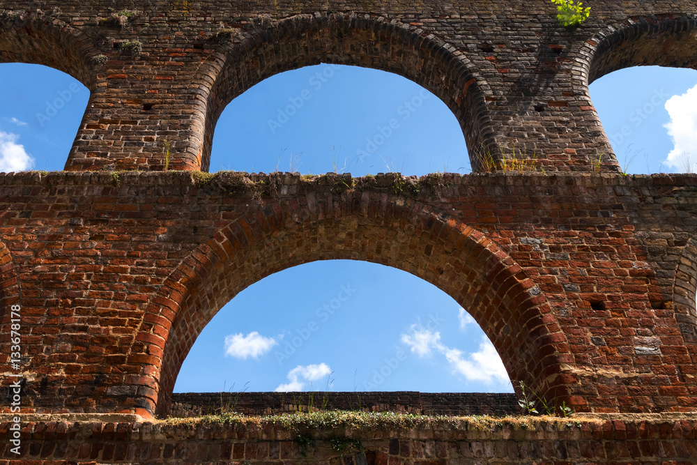 empty window arches and blue sky in the brick wall of the monastery ruin of Bad Doberan, Germany