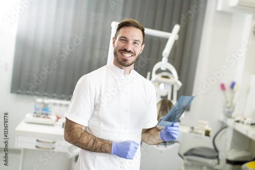 Dentist analyzing x-ray of teeth