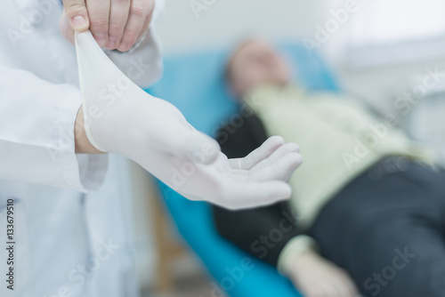 Hands of urologist wearing rubber gloves before the examination