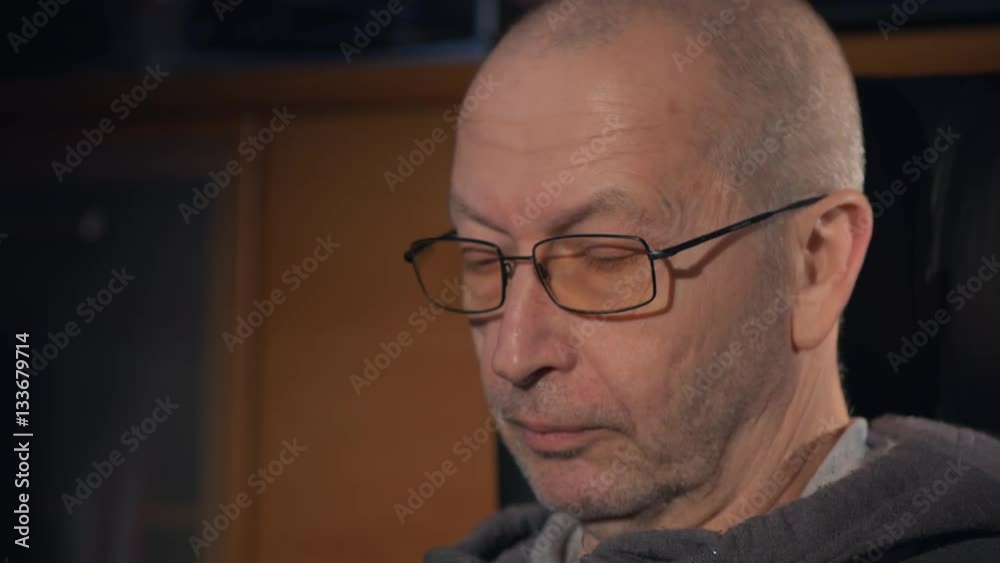 Old man reading book on tablet computer at home Old man reading book on tablet computer at home