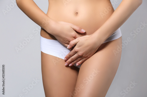 Close up view of young woman on grey background. Gynecology concept