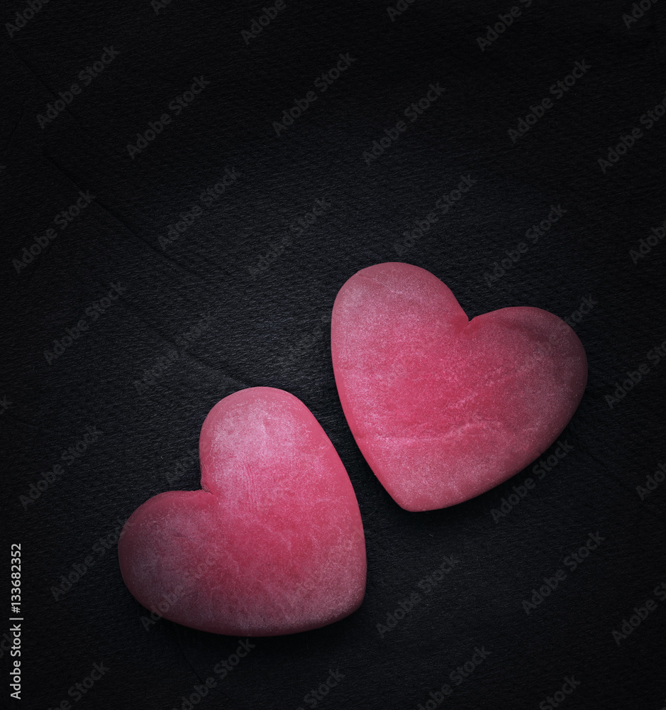 Fototapeta premium Two red hearts on a dark background, soft focus. Romantic card. Declaration of love in vintage style. Gift by St. Valentine's Day.