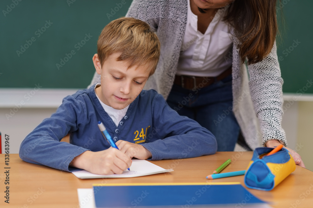 lehrerin hilft einem jungen im unterricht