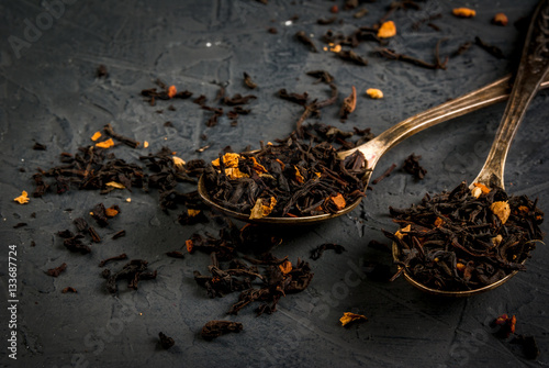 Selection of fragrant teas with dried fruits and spices in teaspoons, that a dark background, copy space