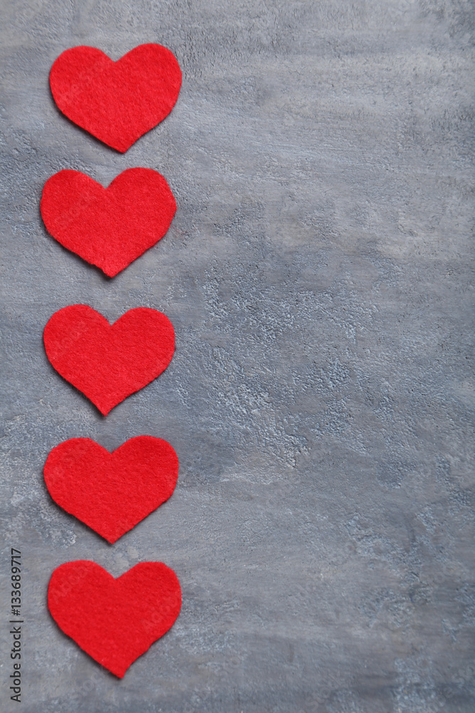 Red hearts on a grey table Red hearts on a grey table