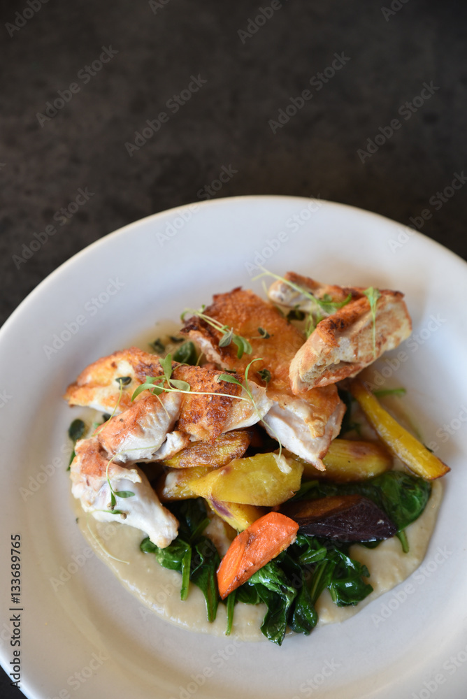 Freshly prepared dish of chicken and vegetables on plate, overhead view Freshly prepared dish of chicken and vegetables on plate, overhead view