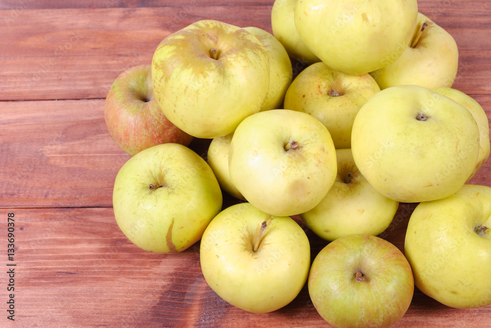 Green apples in a heap on the wooden surface Green apples in a heap on the wooden surface