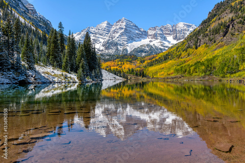 Maroon Bells in Autumn - Autumn view of snow coated Maroon Bells reflecting in crystal clear Maroon Lake, Aspen, Colorado, USA. photo