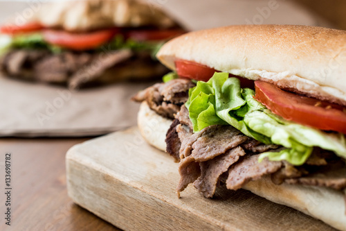 Turkish Pide Doner Sandwich with greens and tomatoes.