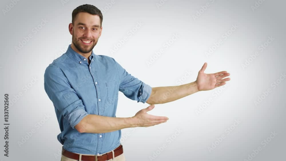 Mid Shot of a Casual Man Making Presenting/ Advertising Gesture. Shot with White Background.