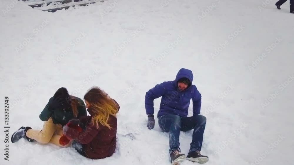 Funny friends playing in the snow on a bright winter day.Slow motion.Aerial shot