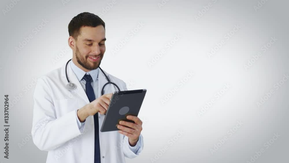 Mid Shot of a Doctor Using Tablet Computer. Background is White. Shot on RED Cinema Camera 4K (UHD). Mid Shot of a Doctor Using Tablet Computer. Background is White. Shot on RED Cinema Camera 4K (UHD).