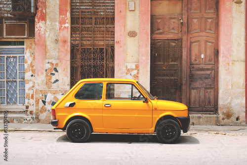 Side view of yellow vintage car parked on the street photo