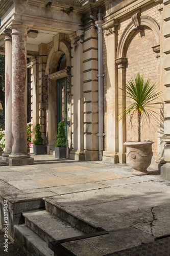 Porch building with columns. Refined Architecture. Palm tree in a pot.