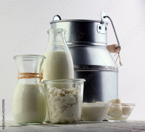 tasty healthy dairy products on a table on: sour cream in a white bowl, cottage cheese bowl, cream in a a bank and milk  jar, glass bottle and in a glass