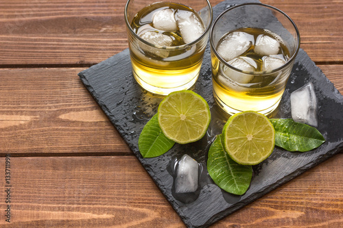 glass of whiskey on wooden background