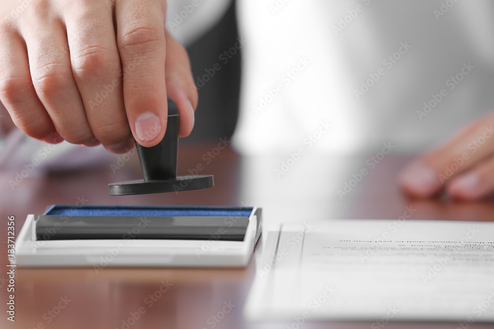 Notary public pressing stamp into ink pad Notary public pressing stamp into ink pad