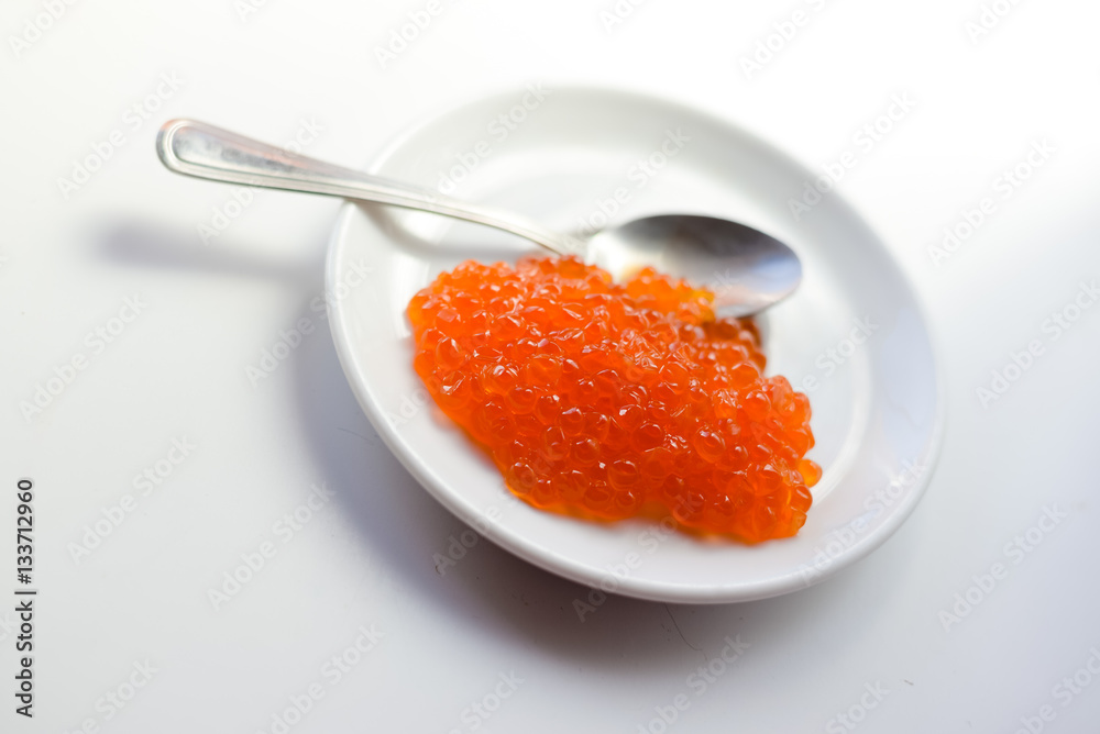 Eggs of red caviar on white surface background. Top view flat lay image Eggs of red caviar on white surface background. Top view flat lay image