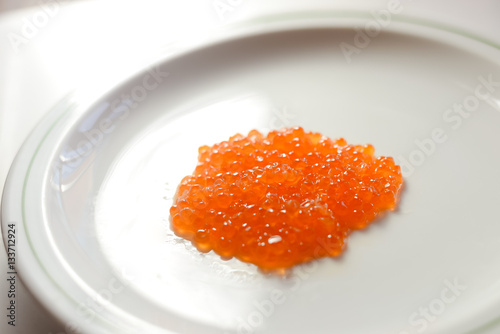 Eggs of red caviar on white surface background. Top view flat lay image