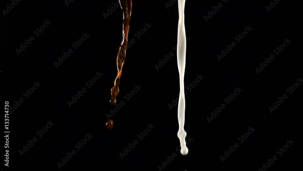 Pouring coffee and milk and making splashes on black background