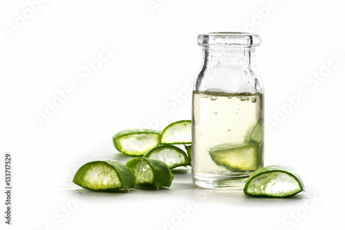 Slices of fresh aloe vera leaf and a bottle with the transparent gel, isolated on white