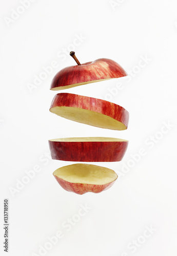 Fresh red golden delicious apple cut into slices floating