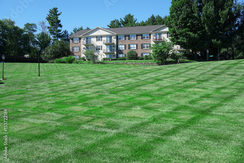 apartment building with large green front lawn © nd700