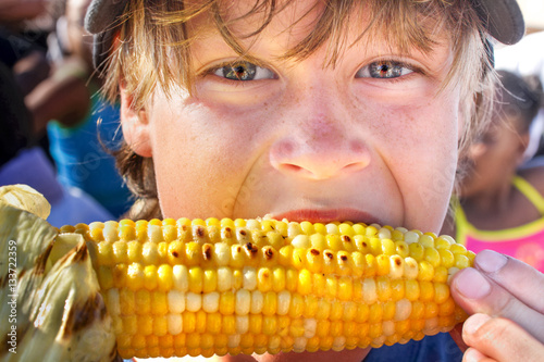 Принти на полотні Happy boy eating corn on the cob