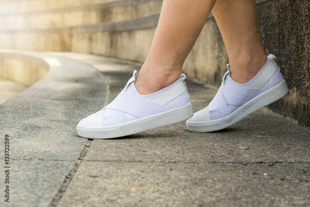 Woman legs wearing white shoes sitting sport. Woman legs wearing white shoes sitting sport.