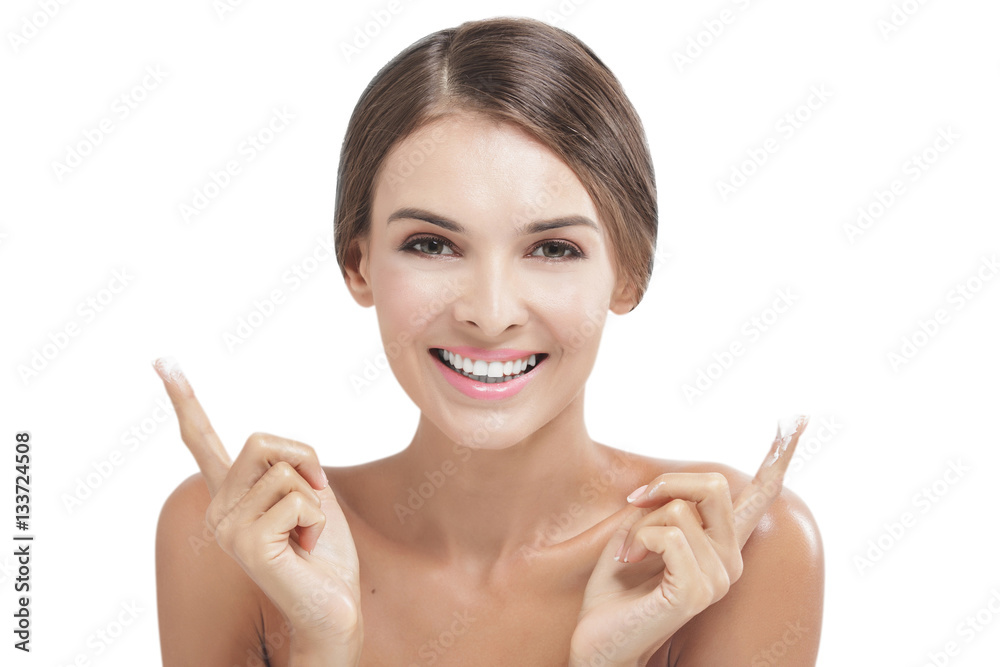 beautiful woman smiling with some facial cream on her fingers beautiful woman smiling with some facial cream on her fingers