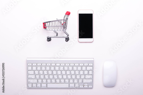 keyboard mouse smartphone and cart on the white background, online shopping concept