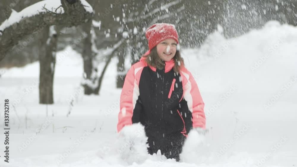 Slow motion of joyful child playing in snow. Happy girl having fun outside winter day Slow motion of joyful child playing in snow. Happy girl having fun outside winter day