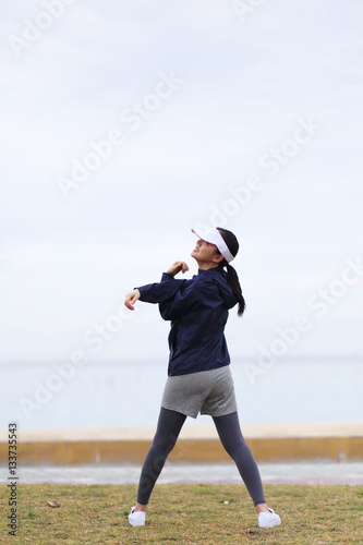 Back view of woman doing exercises on beach