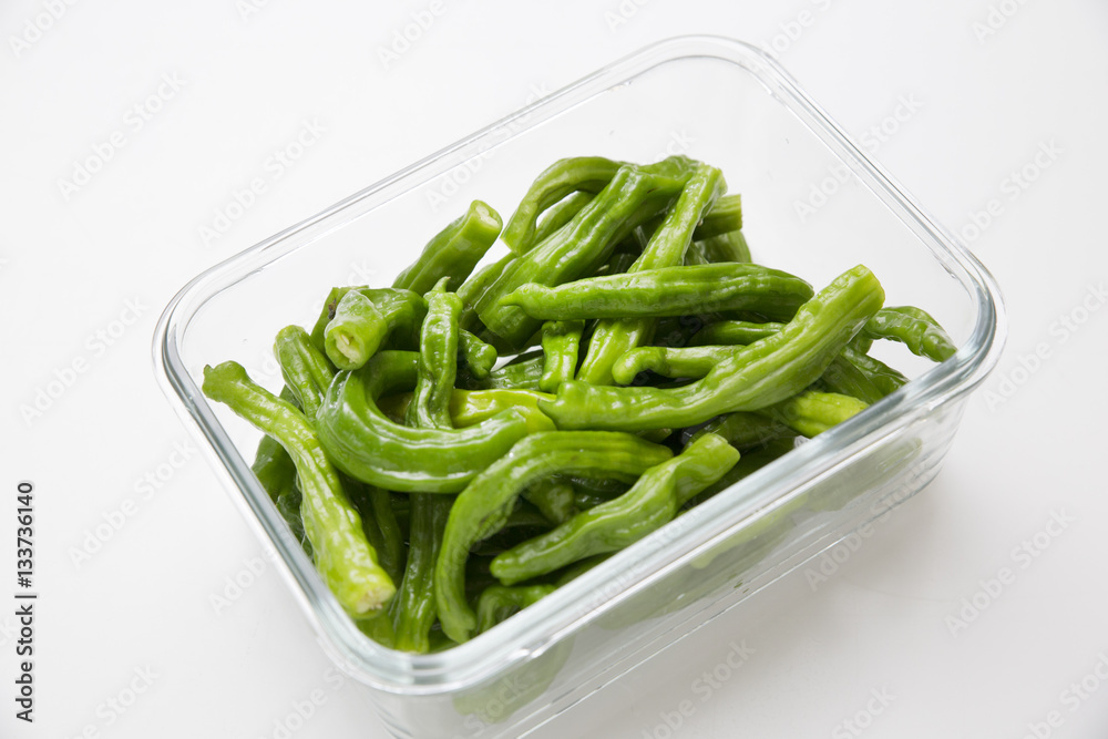 Many green chili peppers in a glass container Many green chili peppers in a glass container