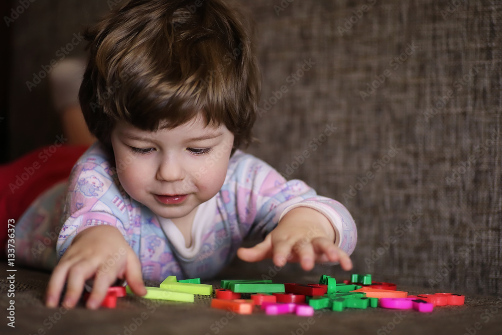child playing with small toys on the couch in room child playing with small toys on the couch in room