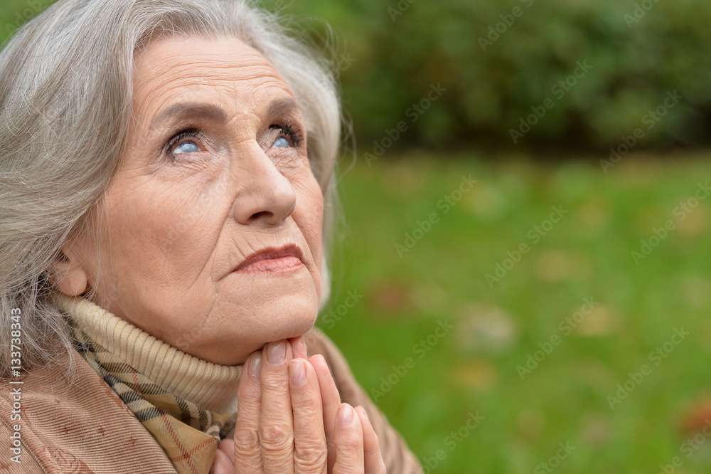 Sad elderly woman in autumn park Sad elderly woman in autumn park
