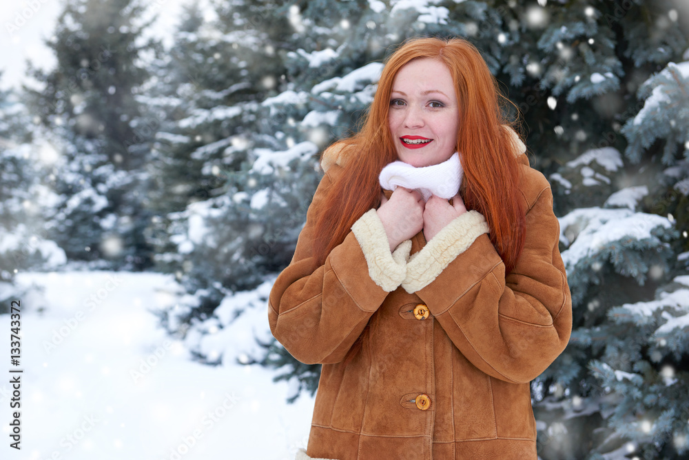 beautiful woman on winter outdoor, snowy fir trees in forest, long red hair, wearing a sheepskin coat beautiful woman on winter outdoor, snowy fir trees in forest, long red hair, wearing a sheepskin coat