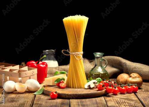 Set Italian ingredients for cooking pasta on wooden table