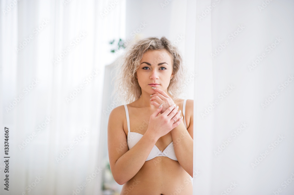 Close up portrait of curly blonde girl at underwear background c Close up portrait of curly blonde girl at underwear background c