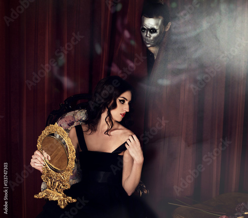The person in a mask behind the back of the girl, The Phantom of the Opera